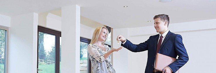 Makler übergibt Schlüssel neue Eigentümerin Makler übergibt Schlüssel neue Eigentümerin