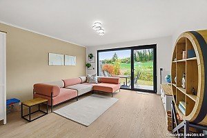 Helles Wohnzimmer, moderne Mblierung, groe Fensterfront, Blick ins Grne, stilvolle Einrichtung, ruhige Lage, ideal zur Vermietung an Amerikaner.